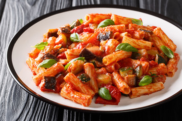 Tortiglioni pasta diet recipe with summer vegetables and basil in tomato sauce close-up in a plate. horizontal