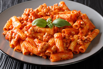 Hot hearty Tortiglioni pasta with bolognese sauce close-up in a plate. horizontal