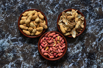 Two bowls with peanuts and one with shells
