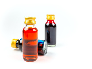 Food coloring in glass bottles on white background isolate, yellow, blue, red, three bottles of food coloring