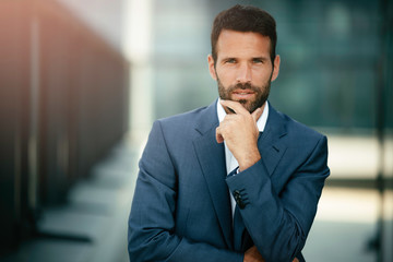 Businessman in a blue suit. Young handsome man outdoors.