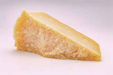 piece of parmesan cheese on a white background closeup