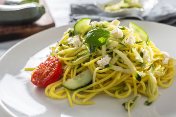 Spaghetti zucchini raw vegan pasta with feta cheese cucumber and basil