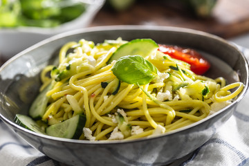 Spaghetti zucchini raw vegan pasta with feta cheese cucumber and basil