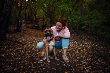 Naklejka na ściany i meble redhaired woman with her dog have fun on the walking