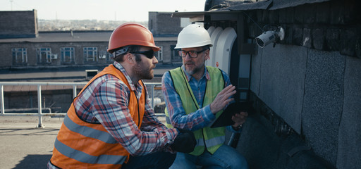 Engineer and technician discussing about security camera
