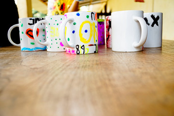 Hand painted mugs are displayed on the table created by girls and boys of an orphanage in a social program. 