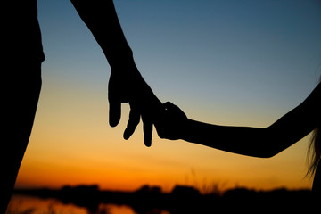 silhouette the parent holds the hand of a child