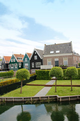Naklejka na ściany i meble View of traditional Dutch houses along a canal in spring, Zaandam, Netherlands