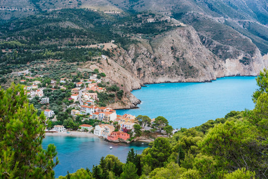 Assos village at Kefalonia island, Greece. Beautiful colorful town at shore with bay lagoon, pine and cypress trees, rocky coastline