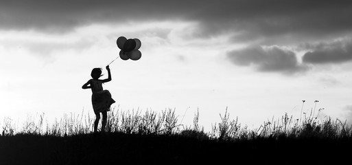 a silhouette   child with balloons