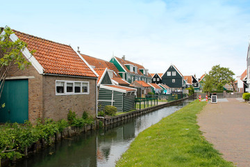 Naklejka na ściany i meble View of traditional Dutch houses along a canal in spring, Zaandam, Netherlands