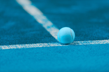 soft focus of tennis ball on tennis grass court. Blue filter