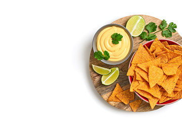 Nachos Mexican corn chips with cheese dip sauce. Vegan nachos snack on wooden board isolated on white background, top view. Tortilla nacho crisps in bowl.