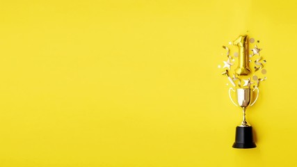 Number 1 gold anniversary celebration balloon exploding from a winning trophy