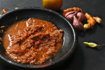 Spicy tomato sauce with a sprinkling of various basic ingredients on the edges