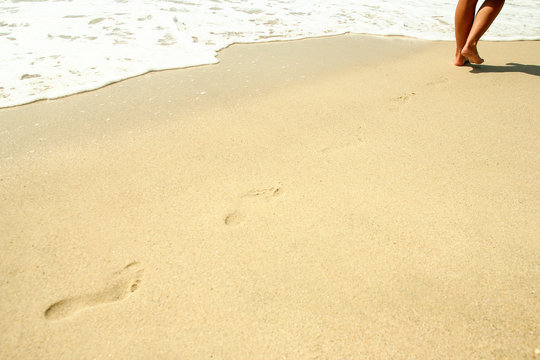 footprints in the sand on the beach