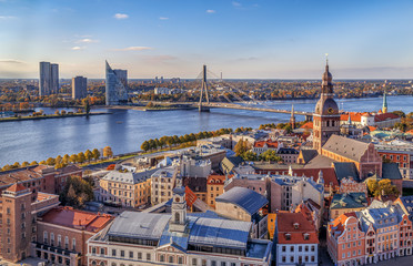 Riga, Latvia. Aerial panoramic view from the tower of St. Peter's Church to the city, Daugava river, historical centre with old buildings and colourful roofs in the foreground. Travel Europe.  - obrazy, fototapety, plakaty
