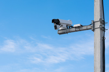 Speed camera. Blue sky background, concrete support.