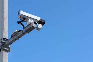 Speed camera. Blue sky background, concrete support, bottom view.