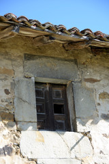 Ventana de un viejo caserío abandonado vista desde fuera un día de sol © Basurde