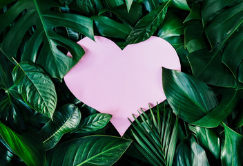 Heart shape cutout with green leaves. Love concept. Flat lay.