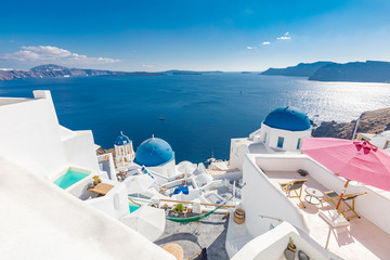Luxury honeymoon and vacation destination, summer travel landscape. Scenic view of traditional cycladic white houses and blue domes in Oia village, Santorini island, Greece