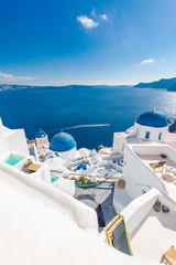 Luxury honeymoon and vacation destination, summer travel landscape. Scenic view of traditional cycladic white houses and blue domes in Oia village, Santorini island, Greece