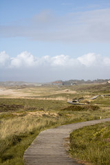 Obraz premium Dunes of Corrubedo, beach and walk, Galicia, Spain. Beautiful wooden walk path in dune beach in the north of Spain. 
