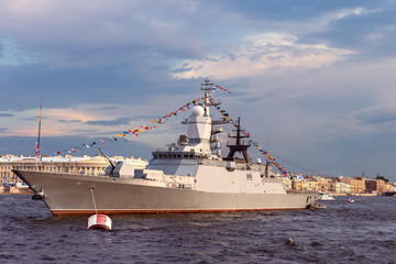 military ship on Neva river in St. Petersburg against the blue sky and the city