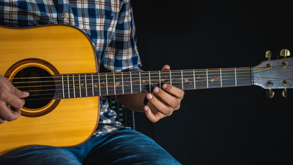 Fototapeta premium A guitarist playing a note on an acoustic guitar