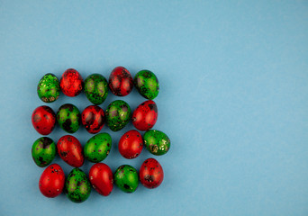 Easter eggs background. Green and red eggs. Colorful Quail colored eggs. Place for text. Different little painted egg set. Dietary nutrition. 