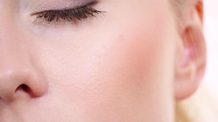 Woman face painting. Makeup artist applying blush rouge with brush to model cheek. Cosmetic beauty procedures and makeover concept.  Slow motion