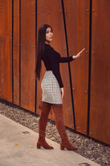 Beautiful girl model posing against the background of the modern building