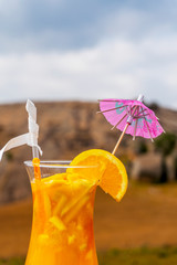 Delicious freshly squeezed orange juice with decorative umbrella outdoor