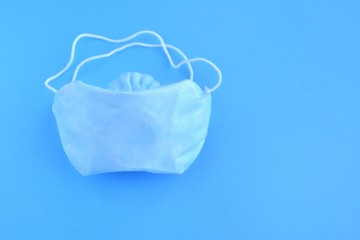 Fototapeta premium Sterile protection face mask against coronavirus ffp2. Increased potential. high demand. face mask against covid-19, virus, flu coronavirus. breathing medical mask on blue background 