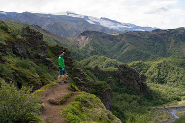 Fototapeta na wymiar Man hiker on a top of a green mountain