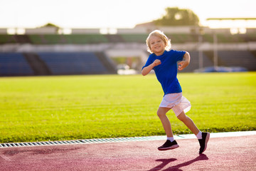 Obraz premium Child running in stadium. Kids run. Healthy sport.