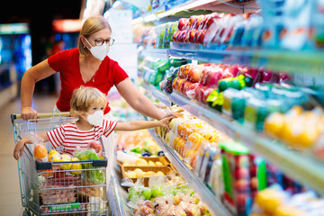 Mother and child buying fruit in supermarket.