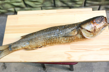  salted, smoked and dried fish, beer snacks, tasty fish on a wooden board