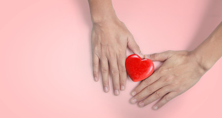 Hands holding a red heart. and donation concepts