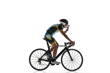 Triathlon male athlete cycle training isolated on white studio background. Caucasian fit triathlete practicing in cycling wearing sports equipment. Concept of healthy lifestyle, sport, action, motion.
