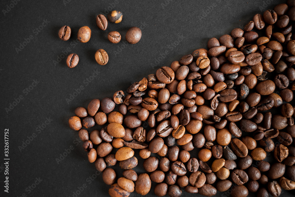 Wall mural roasted coffee beans over black paper background