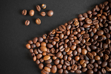 roasted coffee beans over black paper background