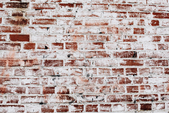 photo of an old brick wall covered with white paint
