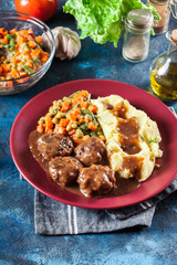 Roasted meatballs in dark sauce with mashed potatoes