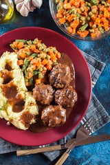 Roasted meatballs in dark sauce with mashed potatoes