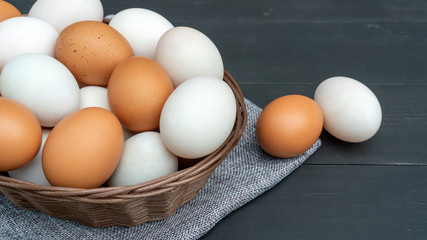 Chicken egg and duck egg on a black wooden table.