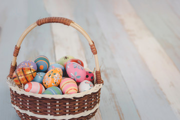 Colorful Easter eggs in the basket on wooden table, festival and holiday spring caming, Easter Calibration