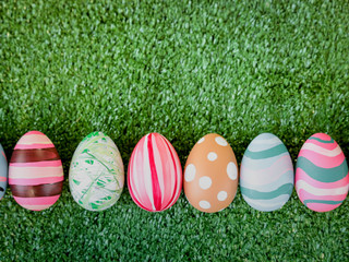 Row of colorful Easter eggs on green grass, festival and holiday spring caming, Easter calibration